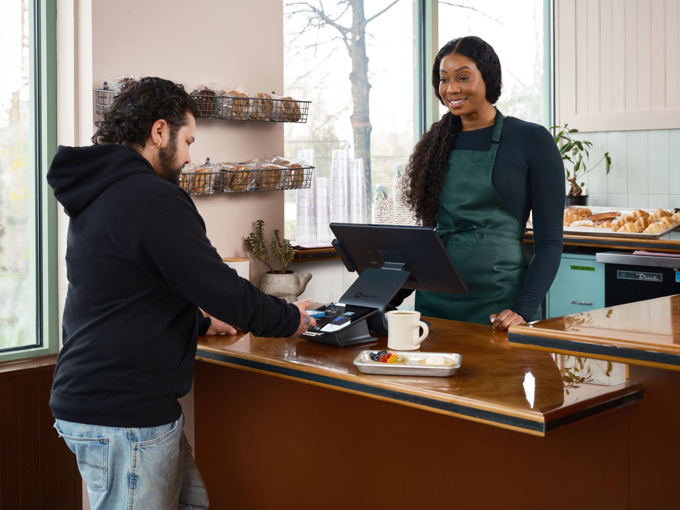 A guest paying at a café counter
