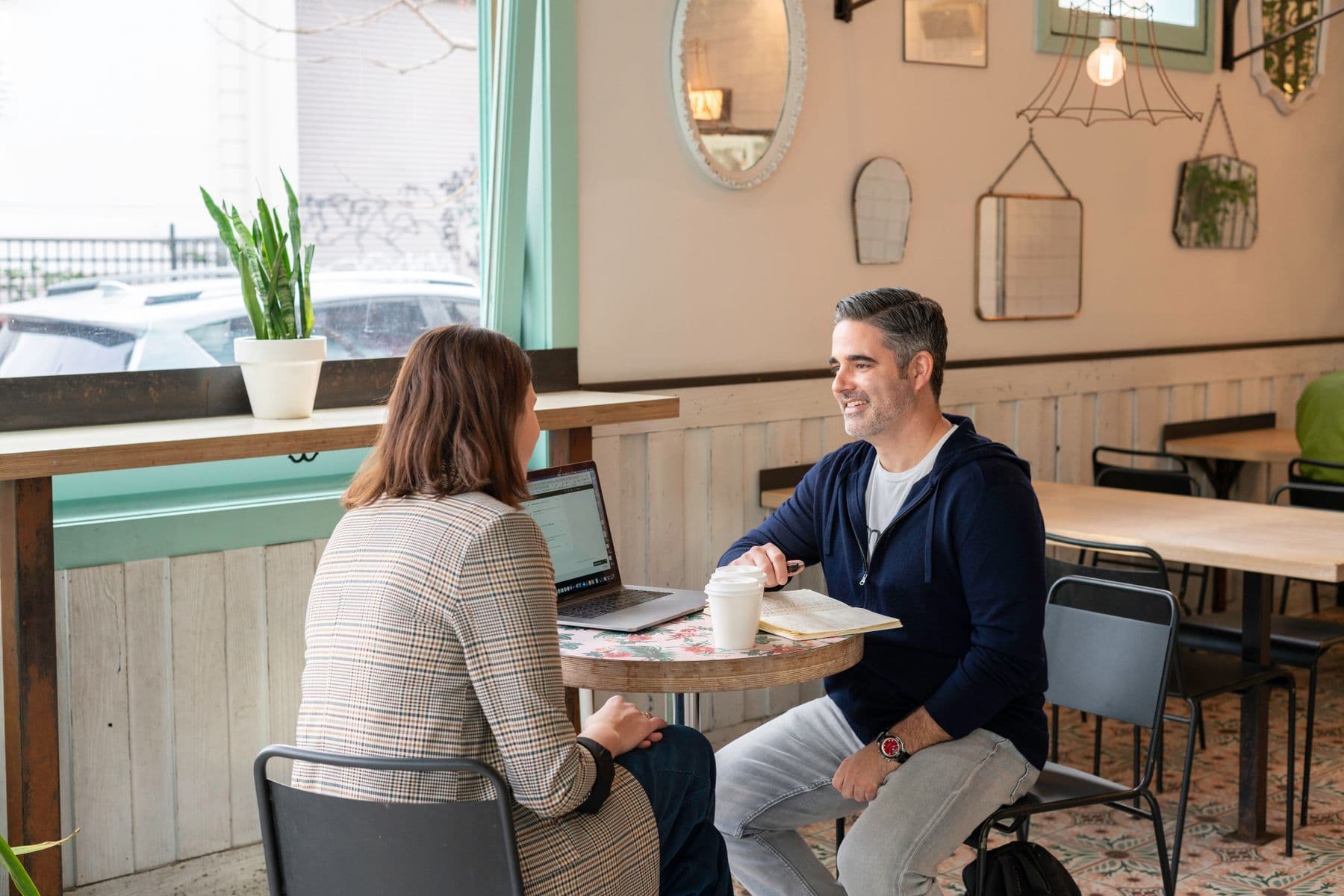 An advisor and a client talking at a café table