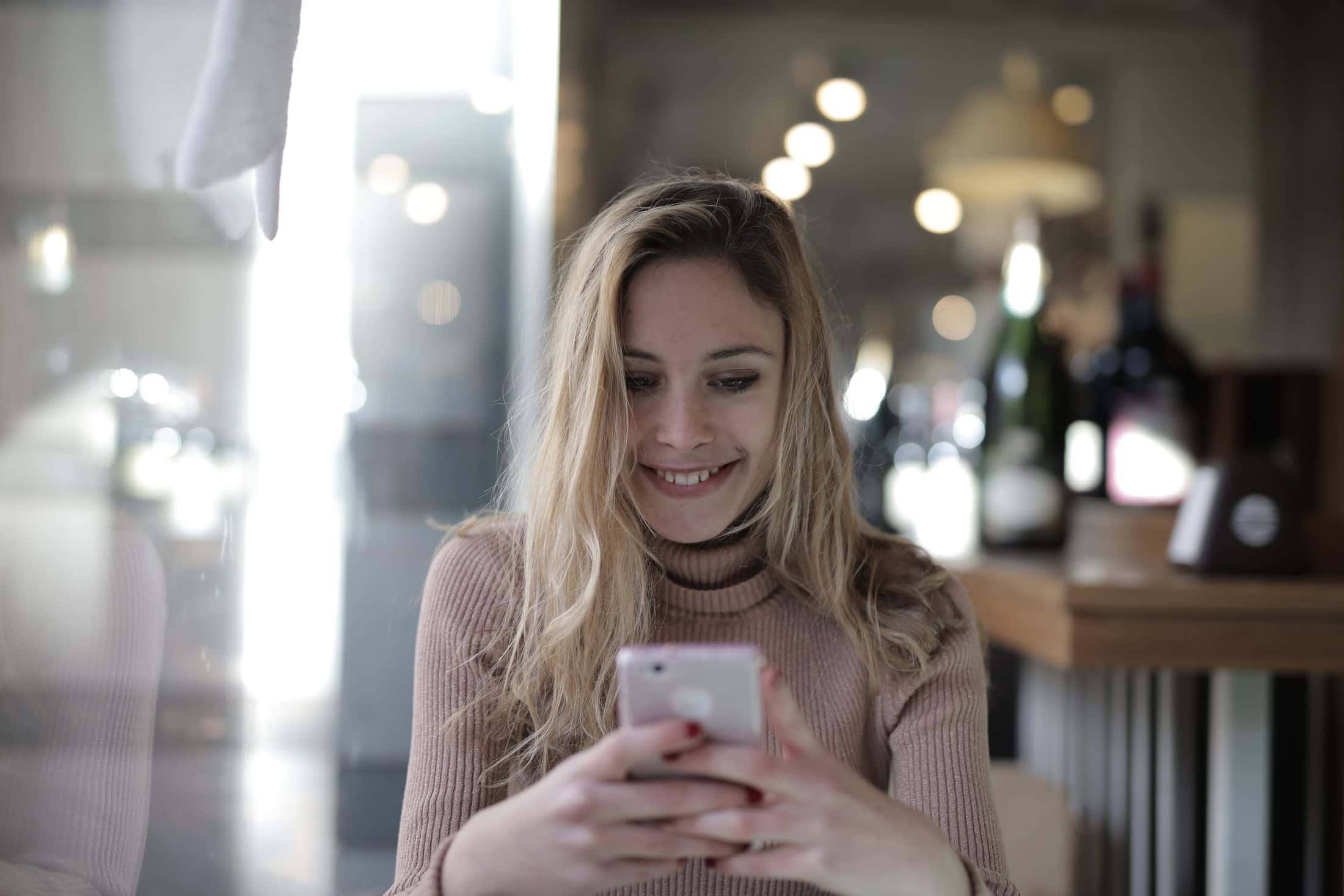 Žena koristi pametni telefon u kafiću